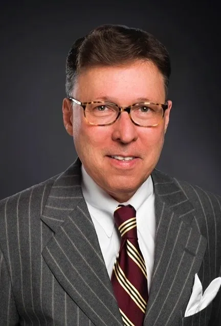 A man in a suit and tie wearing glasses.